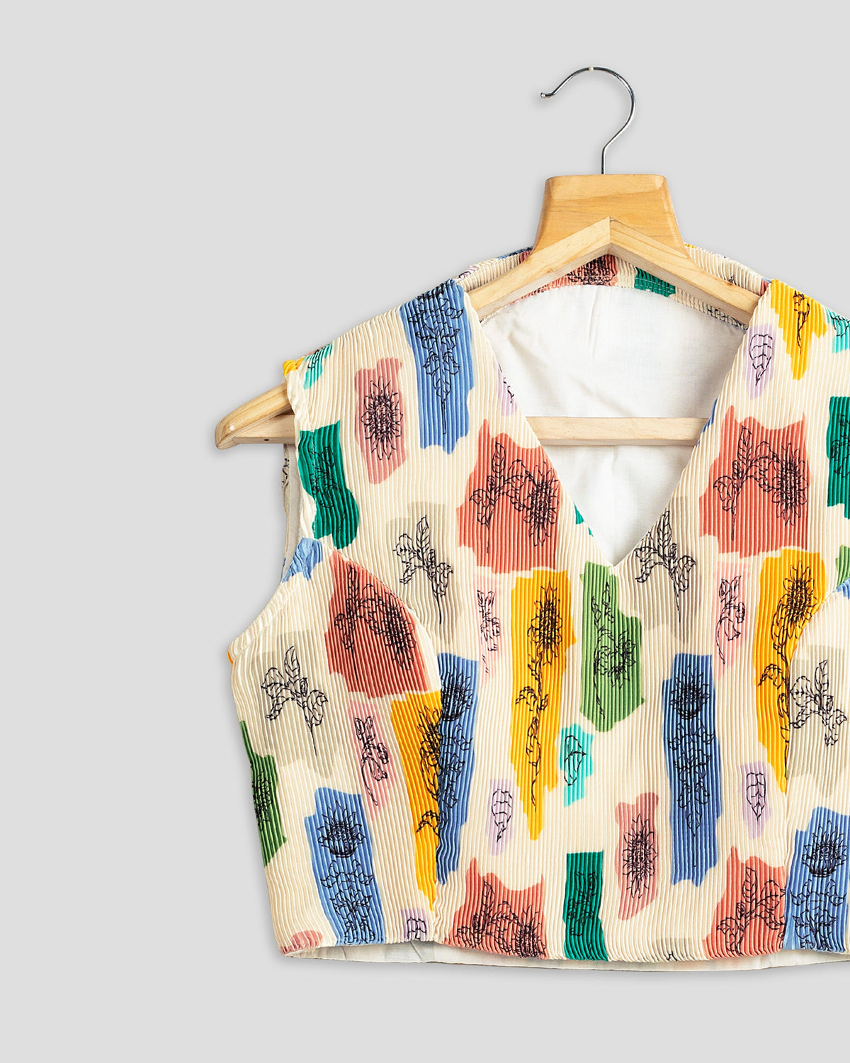 Blusa plisada beige con estampado floral abstracto