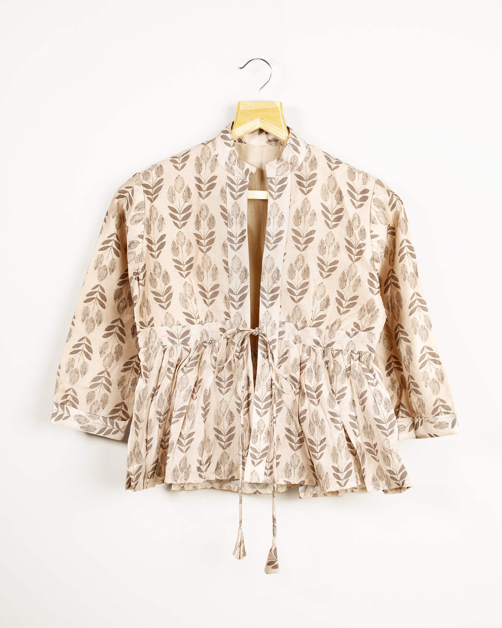 Chaqueta beige y gris con estampado de hojas, cuello y volante