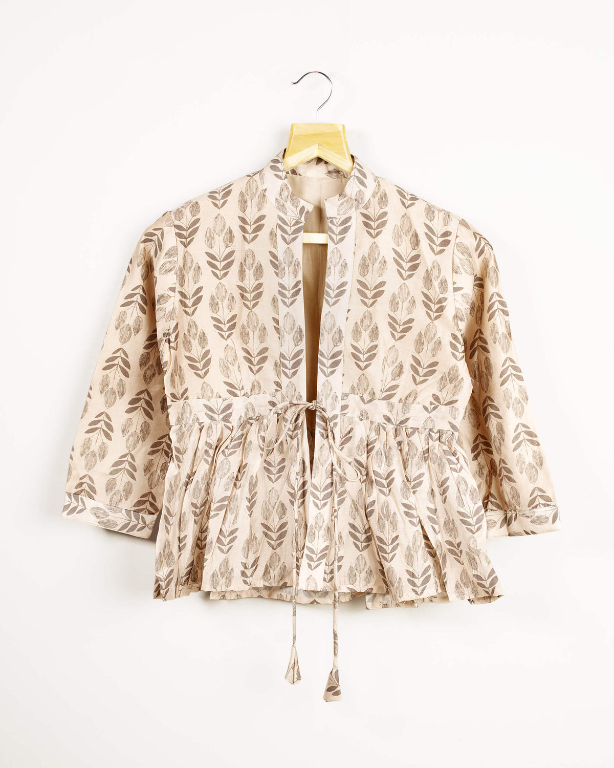 Chaqueta beige y gris con estampado de hojas, cuello y volante